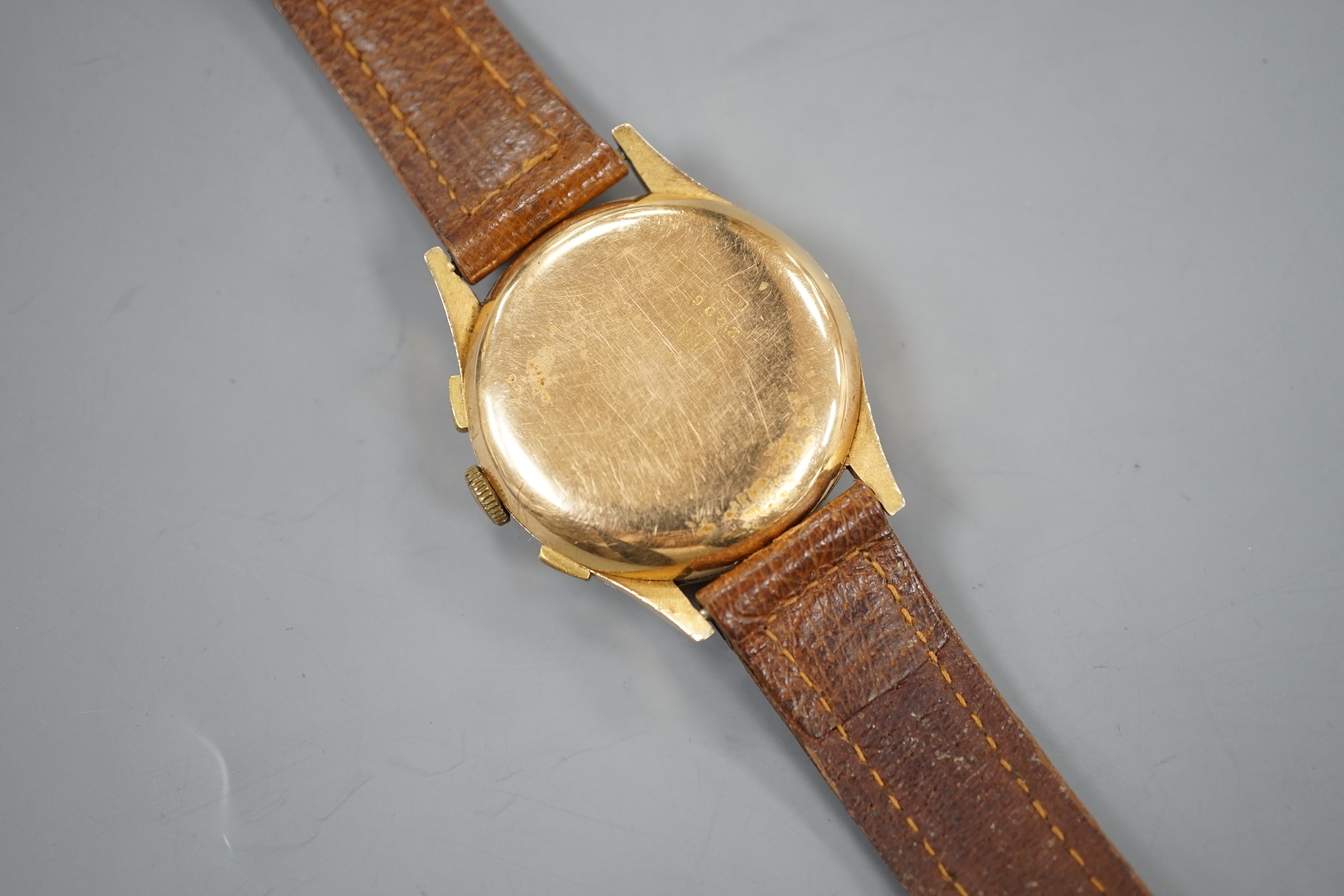 A 1940/1950's? Swiss 18k chronograph wrist watch, with two subsidiary dials, on a brown leather strap, case diameter 37mm, gross weight 45.5 grams.